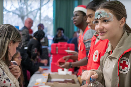 Jeunes bénévoles à la Croix-rouge distribuant des cadeaux pour les fêtes de fin d'année