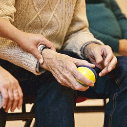 Photo d'une personne âgée tenant une boule de pétanque