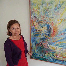 Anncik, bénévole en soins palliatifs, pose devant un tableau