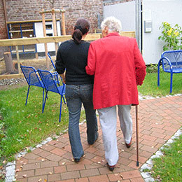 Photo d'un bénévole marchant avec une personne âgée